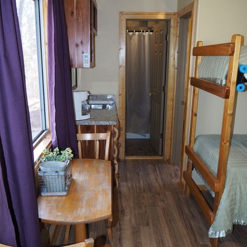 Main room:  includes two twin-on-twin bunk beds, a small dining table, chairs, and a kitchenette / sink.