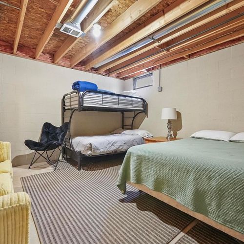 Lower level:  partially-finished basement area includes a queen-size bed, twin-on-full bunkbed, sofa, and dresser.
