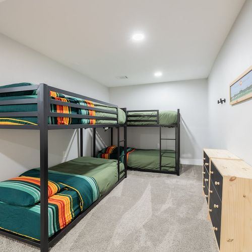 - sleep up to four guests in this playful bunk room with cozy green and striped bedding
- ideal for kids or groups, with plenty of floor space and a sturdy dresser for storage
- bright lighting and simple decor make this a cheerful and practical retr
