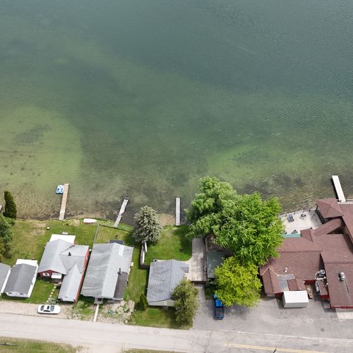 Exterior:  a drone shot of the house from above with the turk lake bar and restaurant just to the right of the house.