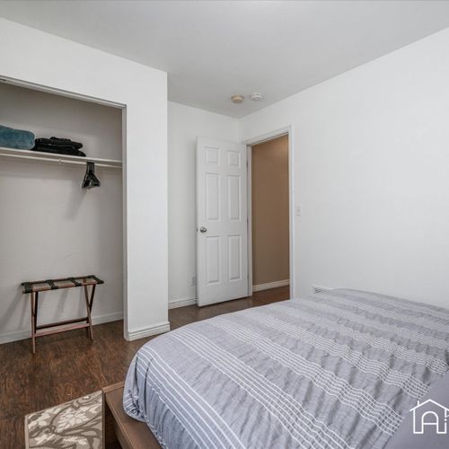 This bedroom is furnished with a queen bed and offers ample storage space and great natural light.