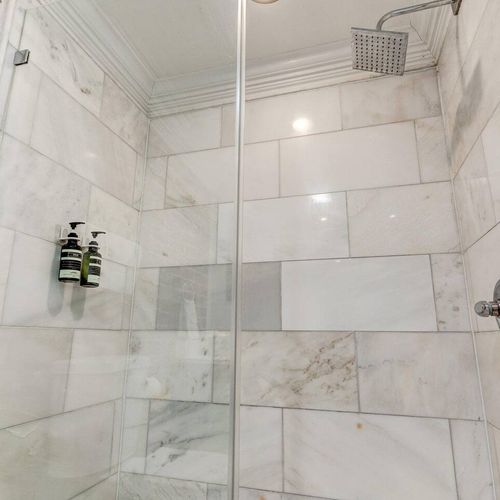 Clean, tiled shower space w/ modern finishes.