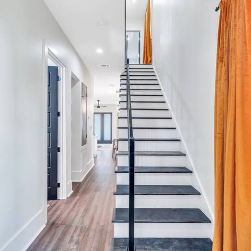 Grand entryway w/ striking black & wood staircase leading up to the bedrooms.