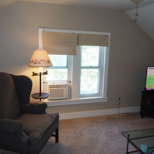 Living room:  very comfortable living room with sofa, coffee table, chair, lamp, and window a/c unit.