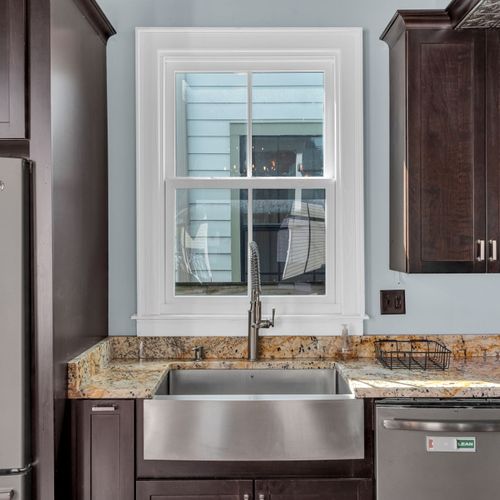 Bright bathroom w/ warm stone countertops & natural light.