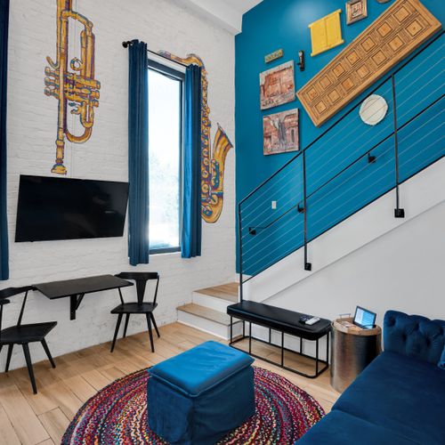 Bold teal walls & a mounted TV set the mood in this jazzy, New Orleans-inspired room.