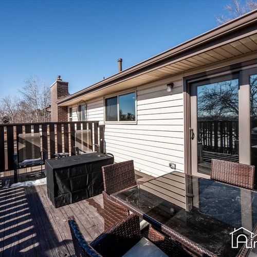 - enjoy outdoor meals and bbqs on this elevated deck with dining set and grill station
- sliding door connects directly to the kitchen for added hosting convenience
- wood railing and treetop views provide comfort and privacy while dining