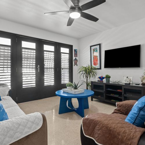 Serene Slumber: Drift off to sleep in this peaceful bedroom, featuring comfortable bedding and charming dark shutters for a perfect night's rest.