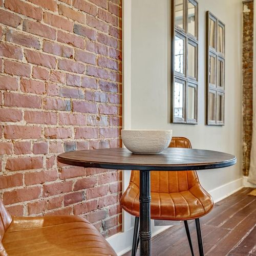 Intimate coffee lounge dining area w/ exposed brick & a cozy round table.