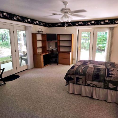 Bedroom #1:  the cabin has a large primary bedroom with a queen-size bed, desk, comfy chair, ceiling fan, dresser, and closet.