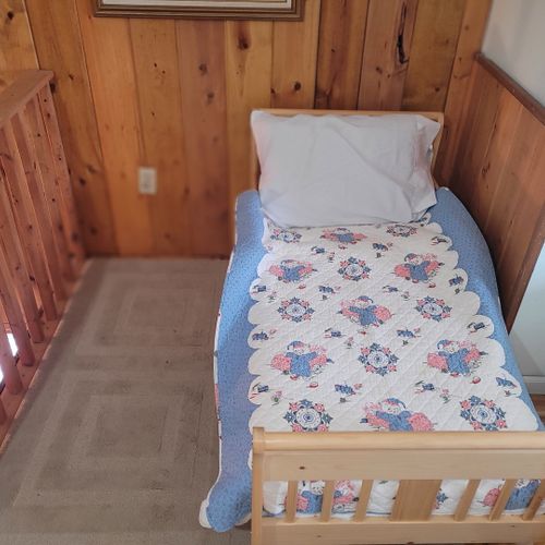 Loft area:  outside of the upstairs bedroom there is a cute loft area with 2 single beds, a small child's bed, and a chair.