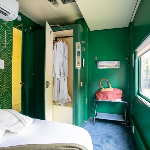The Adirondack Suite equipped with a closet, bedside table, robes and slippers.