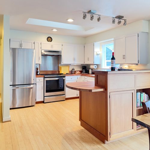 Cook, gather, and linger here. Skylights and warm wood counters brighten the space, with a full kitchen stocked for real meals, a cozy island for morning coffee or wine, and open flow to dining—easy for shared cooking and relaxed evenings together.