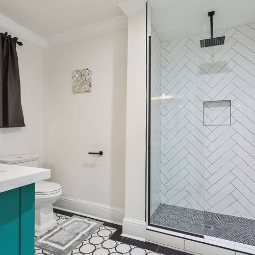 Fresh bathroom w/ herringbone tile accent wall & modern fixtures.