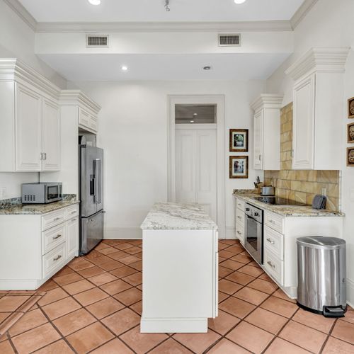 Modern kitchen with marble island and ample counter space.