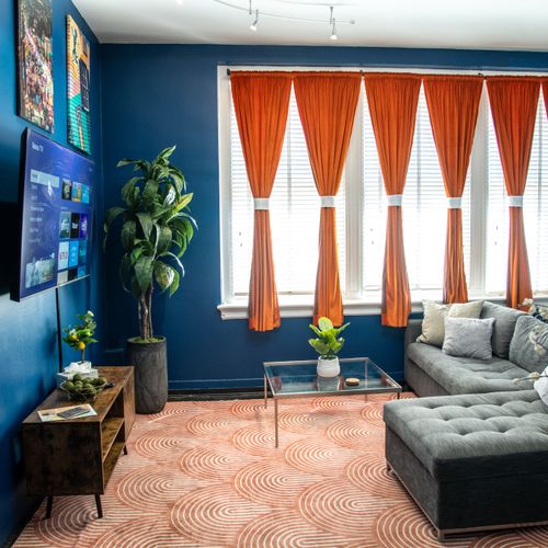 Bold blues, warm light & flowing curtains — a living space full of character & energy.