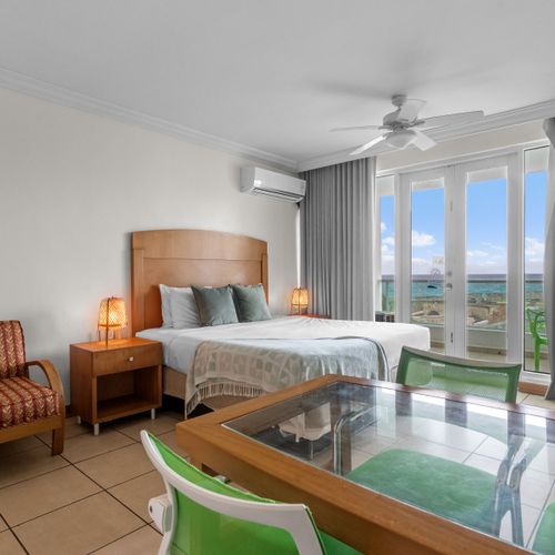 Designed for serene getaways. Experience the best of Condado Lagoon with this bright, airy bedroom featuring a comfortable queen bed and immediate access to your scenic balcony view.