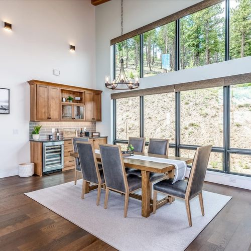 - dine beneath soaring ceilings and massive windows that frame the forested hillside
- rustic wood table and modern chairs blend style with comfort for every meal
- chandelier and natural light make every bite feel like a special occasion