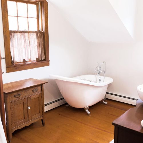 The master bathroom includes a luxurious claw foot tub and natural light.