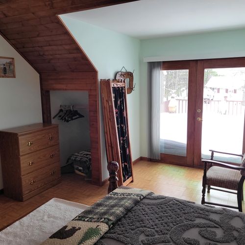 Bedroom #2 (second floor):  very large bedroom features a queen-size bed, walk-out deck, chair, 2 nightstands, 2 lamps, 2 dressers, ceiling fan, television, and private en suite full bathroom