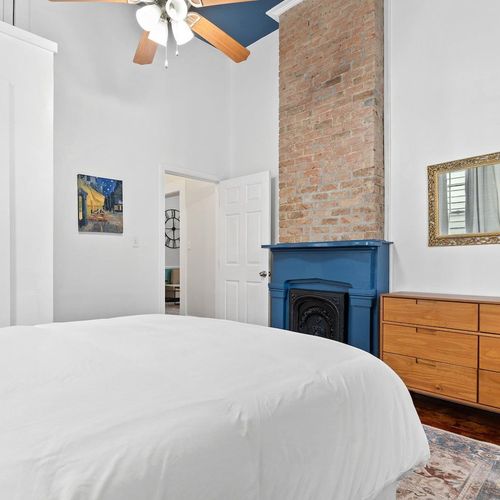 Cozy bedroom corner w/ a fireplace & soft textures for a warm, restful feel.