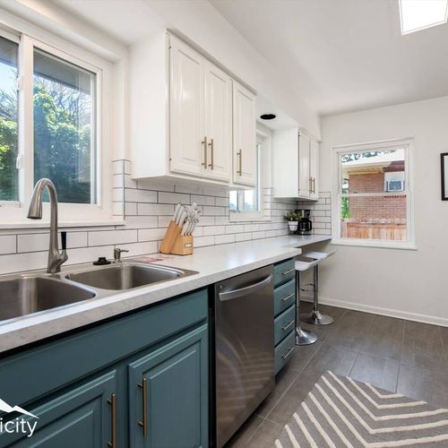 - double sink, quartz counters, and tile accents combine beauty and function
- bar stools sit under the window nook, perfect for sipping coffee or wine
- fresh air and leafy views stream in through sunlit corner windows