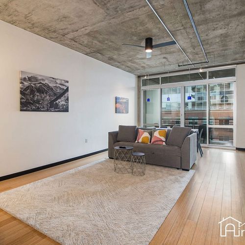 - spacious living area with polished floors, exposed ceiling, and loft style layout
- floor to ceiling windows fill the space with light and cityscape views
- comfortable seating and sleek design create a modern downtown retreat