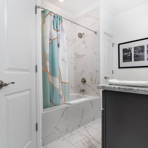 Warm wood vanity adds a charming touch to this bathroom.