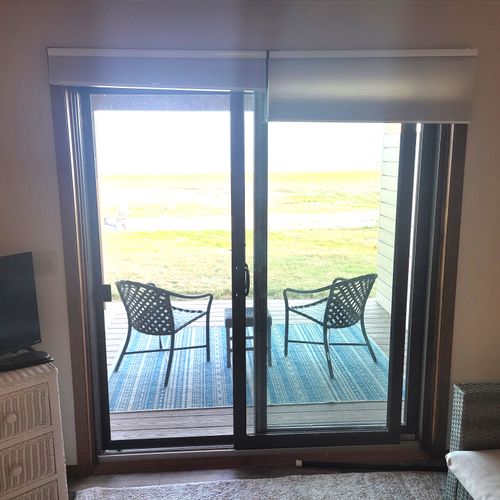 BEDROOM #1 (PRIMARY):  Features a queen-size bed, sofa bed, lakeview, private ensuite bathroom, private entrance from the back patio, private television, nightstand, lamp, ceiling fan, dresser, and shelves