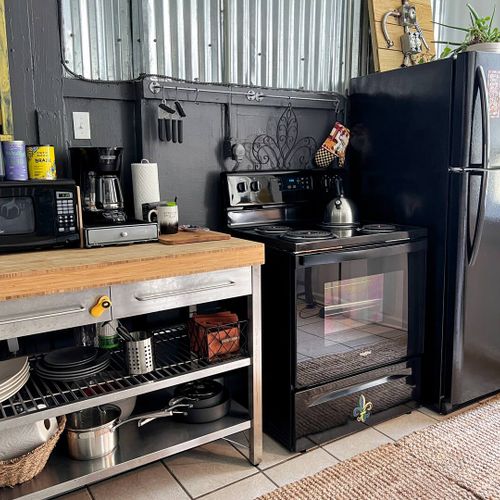 Compact kitchen w/ essentials & a wooden counter for easy meal prep.