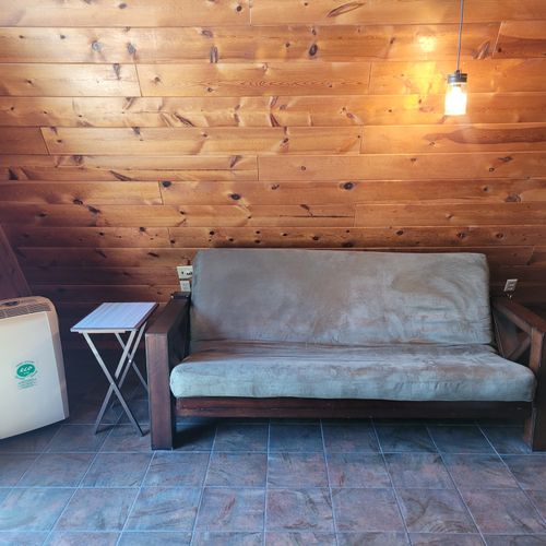 Living room:  features a sofa, futon, and a large television with cable television.