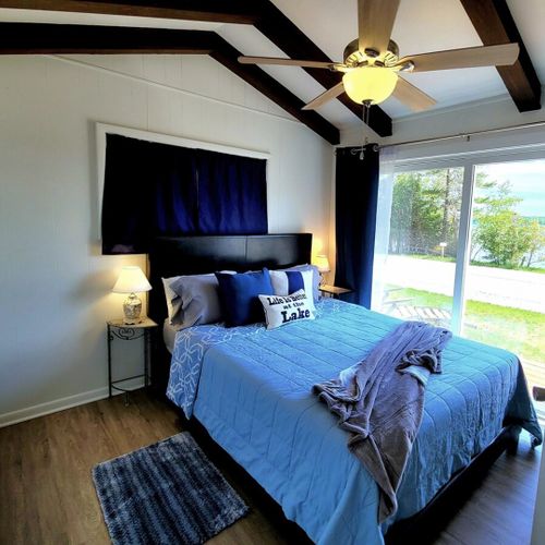 Bedroom #1:  bedroom #1 features a queen-size bed, private entrance, a great view of crystal lake, a ceiling fan, matching nightstands with lamp, a closet, and its own television.