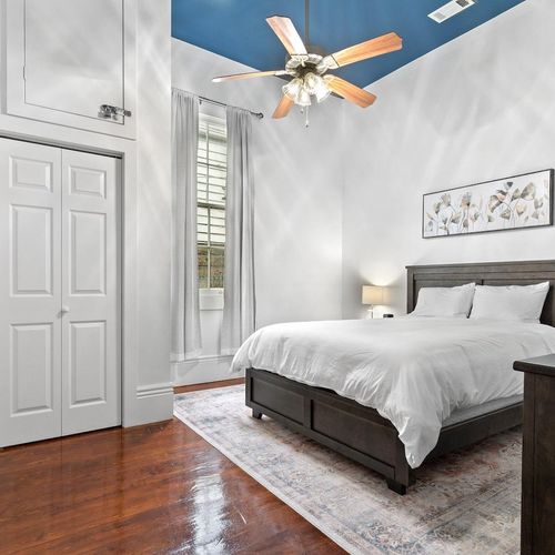 Bright, airy bedroom w/ warm wood floors & plenty of natural light to wake up refreshed.