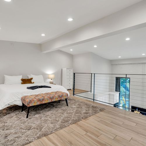 Spacious and airy, this upstairs bedroom features large windows, recessed lighting, and cozy vibes—perfect for unwinding above it all.