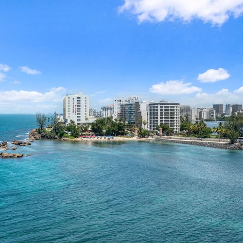 Your private window to paradise: a sweeping vista of the sparkling lagoon meeting the vast ocean and urban charm