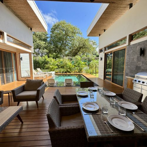 Outdoor dining area with round table at Dos Playas vacation rental in Tamarindo Costa Rica with private pool and tropical garden