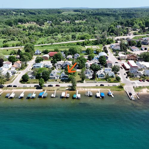 EXTERIOR:  A broad view from over Crystal Lake showing the cottage via the orange arrow with the Beulah boat launch, public fishing pier, and downtown Beulah at the right of the photo.