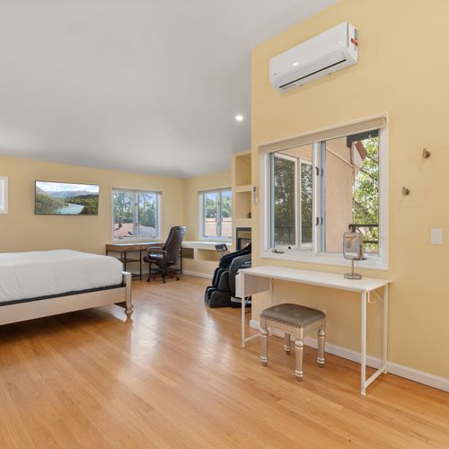 Luxurious master bedroom with king‑size bed, vaulted ceilings, and private deck access.