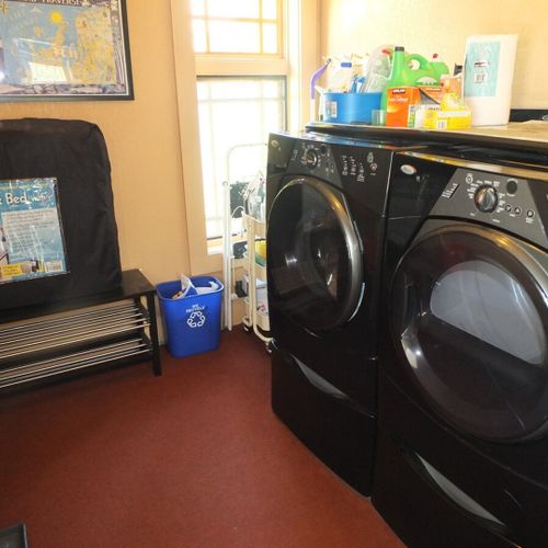 Laundry room:  a closer view of the large front load washer and dryer in the laundry room. The fold-out bed is also shown in the photo.