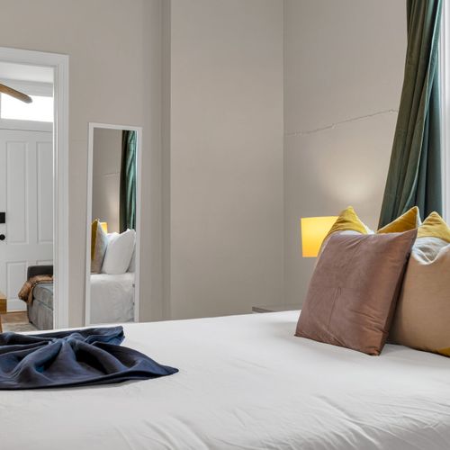 Bright, clean bedroom w/ crisp white bedding & soft natural light for a restful stay.