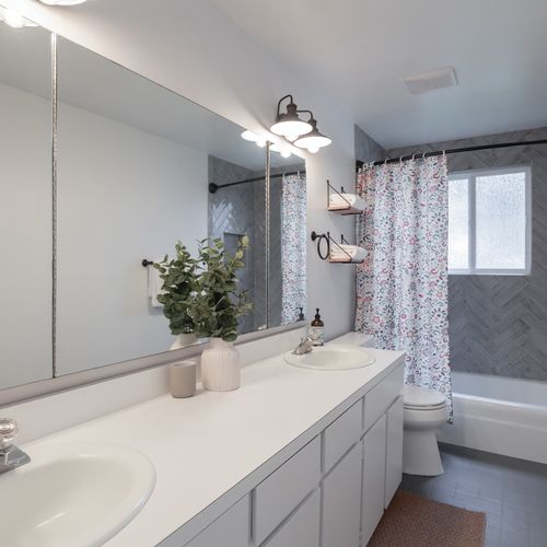 Shower/tub combo with two bath towels, hand towels, and washcloth for each guest.
