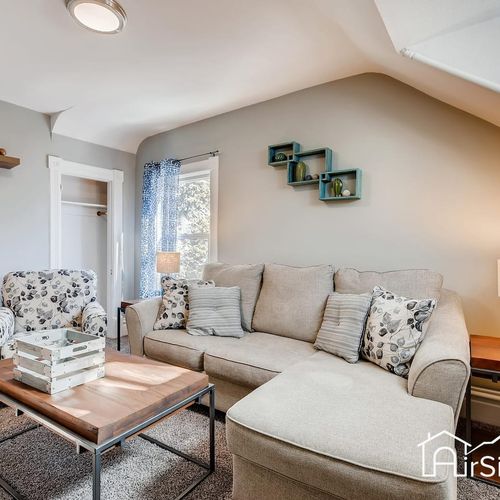- comfy second floor lounge with sectional, floral chairs, and rustic modern touches
- soft lighting and playful wall shelving give the space personality and ease
- great for quiet reading, conversation, or a cozy evening wind down