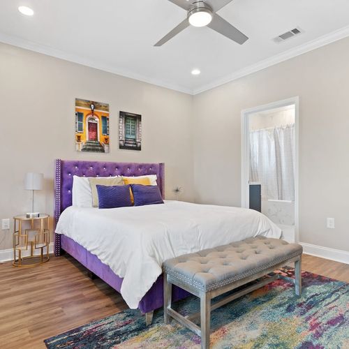 Sunny bedroom w/ a plush bed & warm décor for a cozy, comfortable stay.