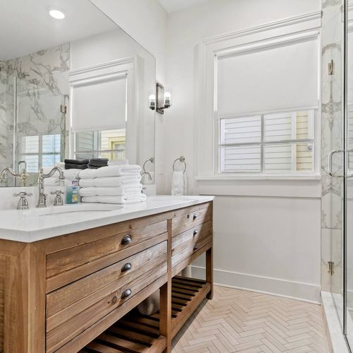 Bright bathroom w/ wood vanity, sink & plenty of counter space.