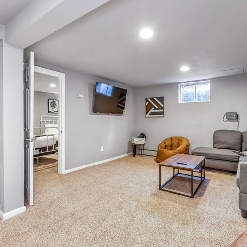 The downstairs area features a dartboard, foosball table, board games, and a flat-screen tv in the second living space.