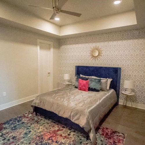 Restful bedroom w/ blue upholstered bed & warm, layered bedding.