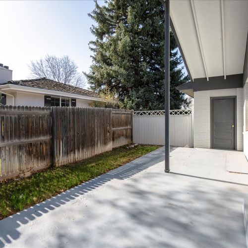 The wraparound covered patio is smoothly paved with access to the front yard and garage.