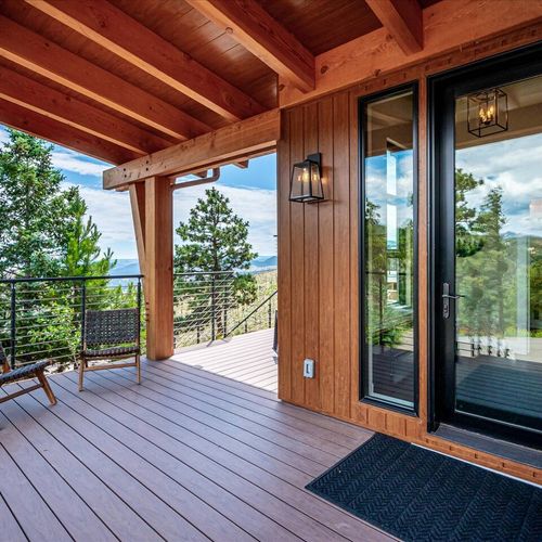 - step outside to a covered deck with rich wood textures and stylish outdoor lighting
- grab a seat and soak up views of the forested hills and wide open skies
- peaceful transition between indoor style and natural surroundings awaits