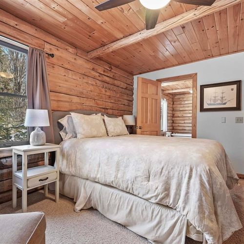 Bedroom #1 (main floor):  features a queen-size bed, chair, nightstand, closet, ceiling fan, and private bathroom entrance.