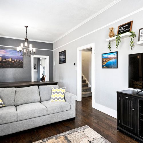 - open concept layout connects the cozy living area with dining and kitchen zones
- wall art and greenery add personality to this light-filled, social space
- ideal for groups who want to relax, play games, or enjoy meals together